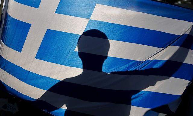 A nationalist holds a Greek flag during a protest against government plans to build the first official mosque in an Athens neighborhood