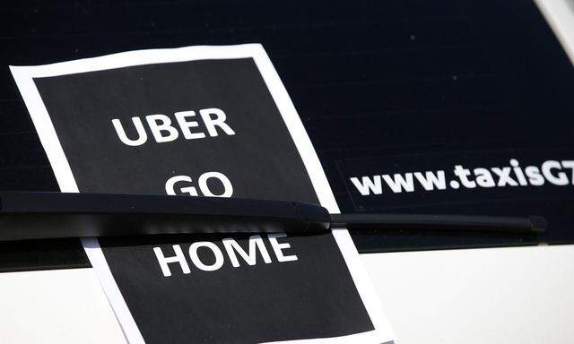 A leaflet which reads 'Uber go home' is seen on a taxi as striking French taxi drivers block the traffic on the Paris ring road during a national protest against car-sharing service Uber, in Paris