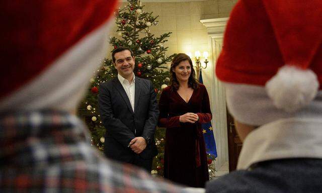 Griechenlands Premier, Alexis Tsipras, und seine Lebensgefährtin während eines Weihnachtsempfangs in Athen. Geschenke verteilen will die Regierung auch im Zuge der Parlamentswahlen im kommenden Jahr.