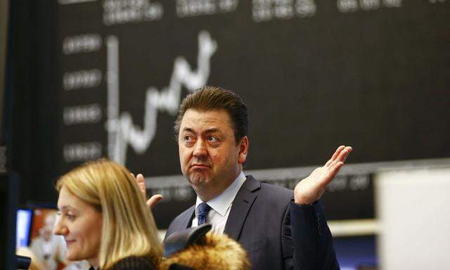 A trader reacts in front of the German DAX Index board at the Frankfurt stock exchange