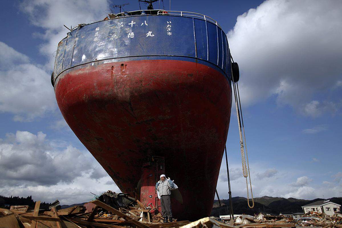 Vorbei am einem riesigen Schiff muss ein Mann in Kesennuma das tragen, was er aus seinem dem Erdboden gleichgemachten Haus zu bergen vermochte. (27. März)