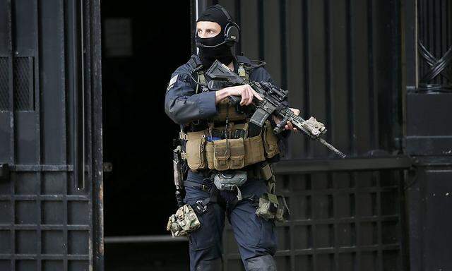 Ein maskierter Beamter vor dem Justizpalast in Paris.