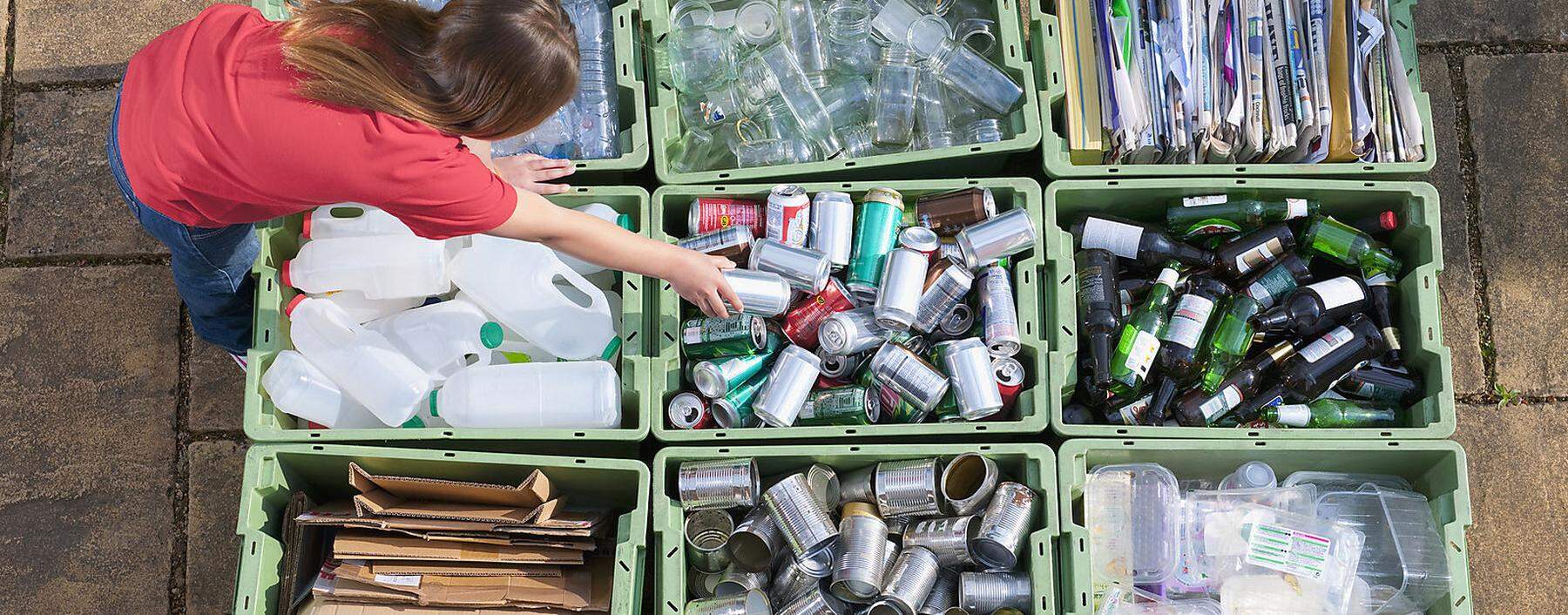 Caucasian teenage girl organizing recycling bins