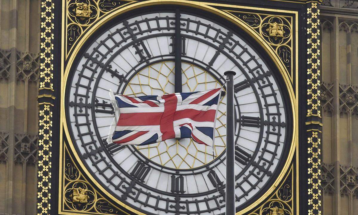 A British Union flag flutters in front of one of the clock faces of the ´Big Ben´ clocktower of The Houses of Parliament in central London