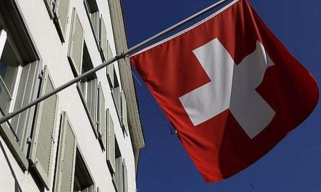 Switzerlands national flag is seen beside the logo of Swiss bank UBS in the town of Riehens national flag is seen beside the logo of Swiss bank UBS in the town of Riehen