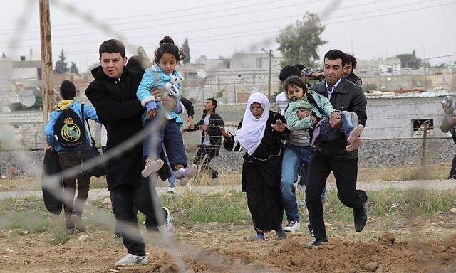 Syrians run to flee from Syrian town of Ras al-Ain to Turkish border town of Ceylanpinar