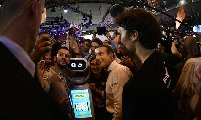 Präsident Emmanuel Macron (Mitte) lässt sich auf einer Technologiemesse in Paris für ein Selfie mit Anhängern ablichten. 