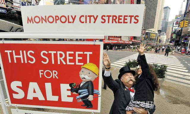 Four-year-old Figueroa helps Mr. Monopoly slide in a board to complete the 'For Sale' sign to promote the unveiling of a new free online Monopoly game in New York