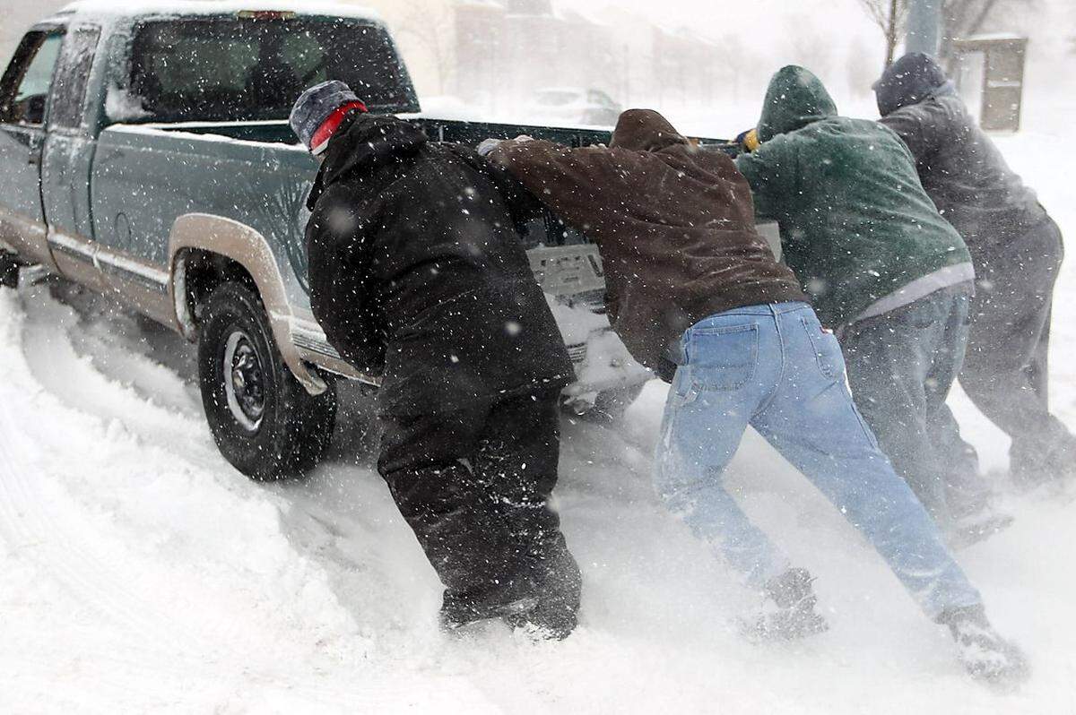 Viele Fahrzeuge blieben in den Schneemassen einfach stecken, wie hier in St. Louis. Wer zufällig vorbeikommt, packt mit an.