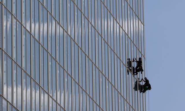 Workers make their way up a high-rise building to clean windows in Vienna