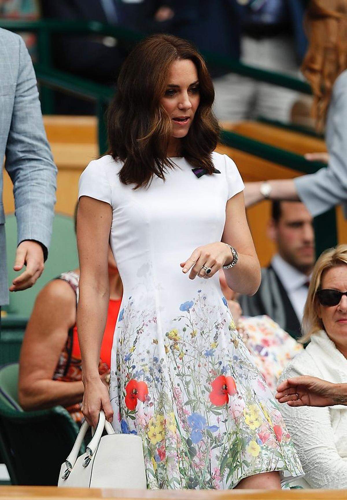 Tennis Whites, Runde zwei: Zum Herren-Finalspiel des Wimbledon-Turniers in London führte Kate erneut ihre Victoria-Beckham-Handtasche aus - diesmal gepaart mit einem Dress mit Blütenprint und Mascherl über der Brust von Catherine Walker. (Nicht im Bild, dennoch getragen: nudefarbene Sandaletten mit Blockabsatz von Stuart Weitzman, goldene Ohrgehänge von Cassandra Goat, Sonnenbrille von Bulgari.)