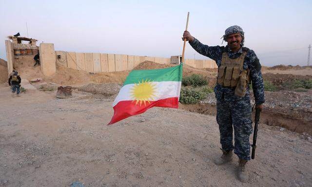 Ein Mitglied der irakischen Truppen hält die kurdische Flagge verkehrt. In Kirkuk wehen jetzt wieder irakische Flaggen.