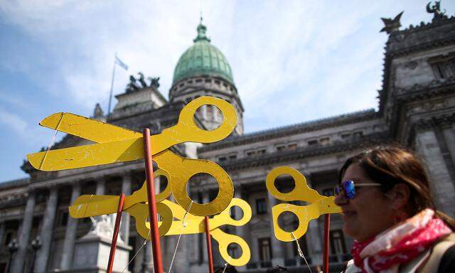 A demonstrator holds scissors cutouts during a national teachers´ strike outside of the National Congress, in Buenos Aires