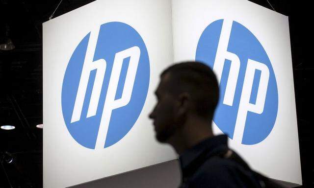 File photo of an attendee at the Microsoft Ignite technology conference walking past the Hewlett-Packard (HP) logo in Chicago, Illinois