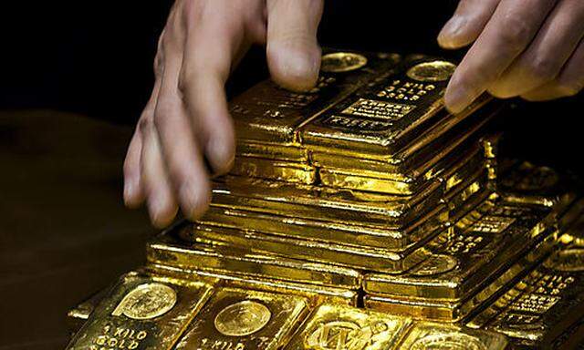 A staff member displays gold bullion bars during a news conference at the Chinese Gold and Silver Exc