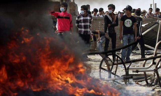 Garment workers hold petrol bombs after clashes broke out during a protest in Phnom Penh