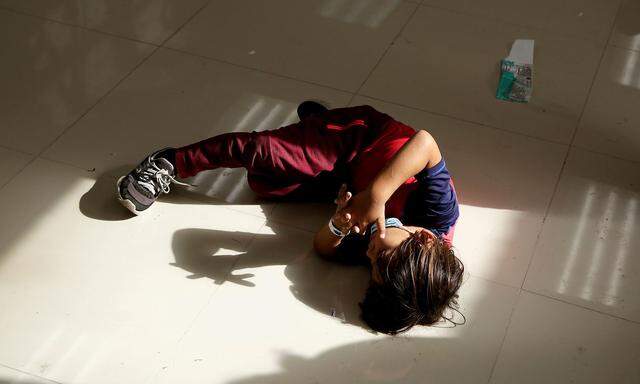 A migrant child from Central America plays with his own shadow inside the office of the Center for Integral Attention to Migrants (CAIM) after being deported with his mother from the United States, in Ciudad Juarez