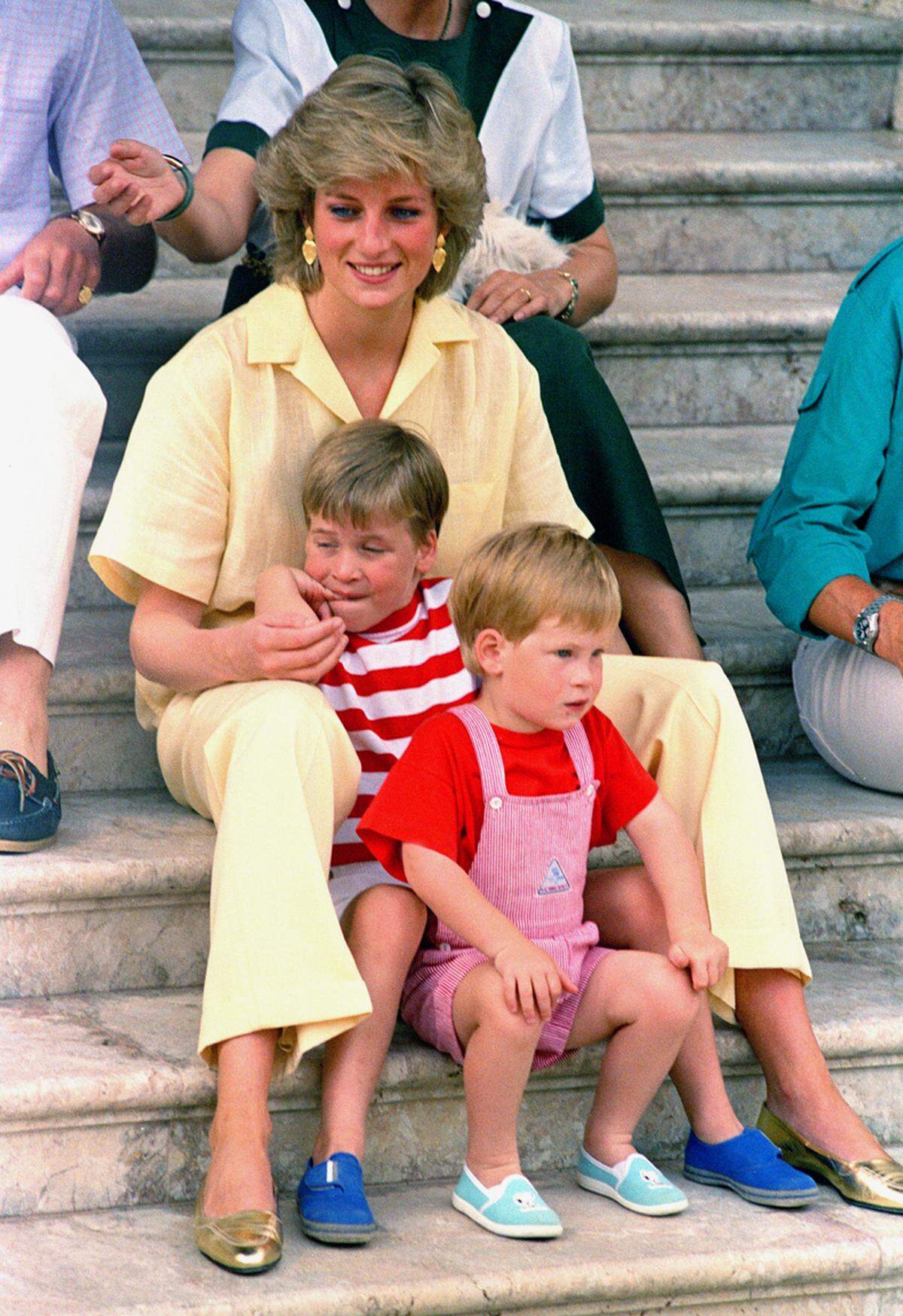 Prinzessin Diana im gelben Leinenanzug mit Prinz William und Harry.