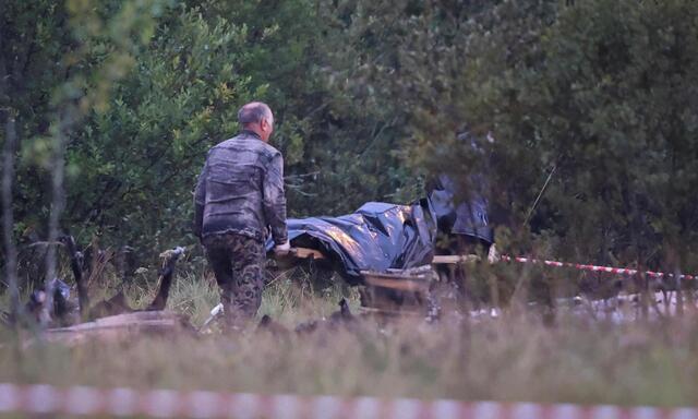 Der Leichnam eines Opfers wird von der Absturzstelle abtransportiert.