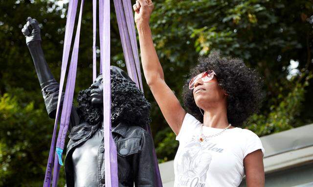 Jen Reid poses next to a sculpture by Marc Quinn portraying her, in Bristol