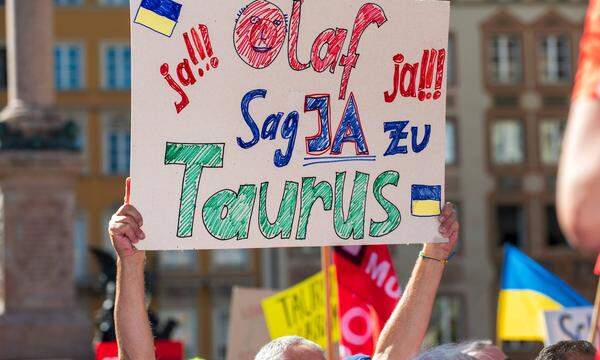 Ein Demonstrant fordert den deutschen Bundeskanzler per Plakat auf, den Marschflugkörper Taurus in die Ukraine zu schicken. 