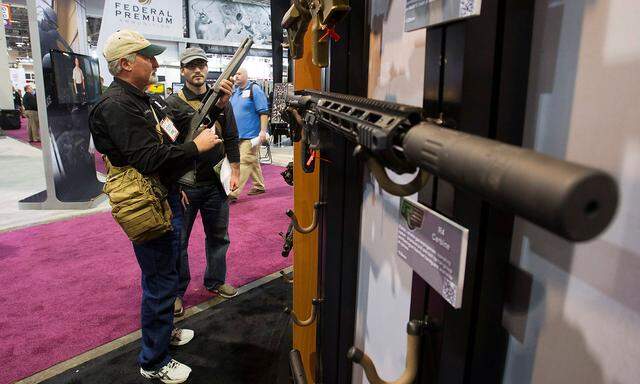 FILE PHOTO: Chadwick and son Joshua of Triple J Firearms look over Remington rifles and shotguns during SHOT Show in Las Vegas
