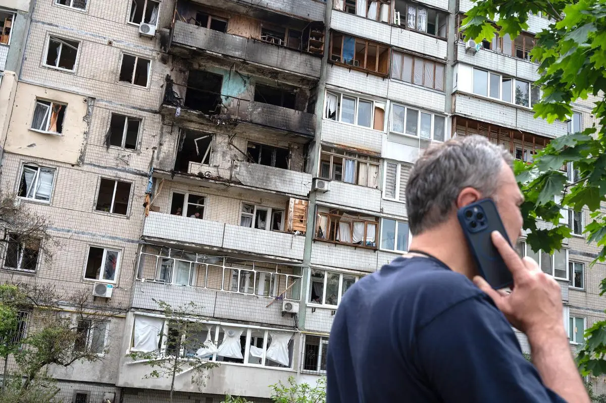 A man in front of a block of apartment in the Obolonskij district, which was damaged by the stroke of rubble during the nightly Russian rocket and drone attack in Kiev, Ukraine, on May 24, 2025. 