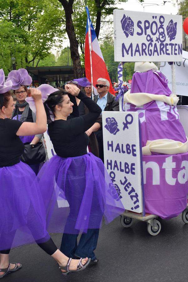 "Wir wollen nicht ein Stück Torte, wir wollen die ganze Bäckerei", sagen diese Damen und legen ein violettes "Tänzchen für die gleiche Bezahlung von Männern und Frauen" ein.