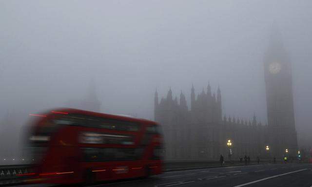 A bus crosses Westminster Bridge on a foggy morning in central London
