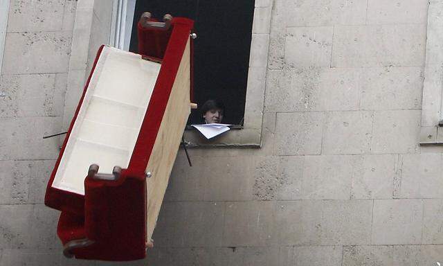 A protester throws sofa out of window of parliament building in Chisinau