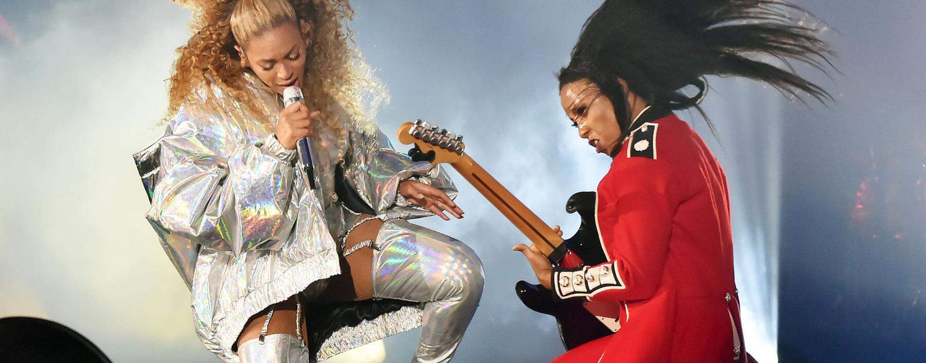 Gitarre als Symbol der Männlichkeit? Auch diese Assoziation ist in den Zehnerjahren verblasst. Geblieben sind (meist unfreiwillige) Saitenwürger- Parodien. Im Bild: Beyoncé, ganz in Weiß, mit ihrer Gitarristin.
