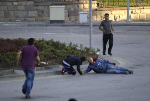 Fernsehsender und Fotografen zeigten in Ankara zahlreiche Menschen, die sich auf den Straßen um Verletzte kümmerten, die am Boden lagen.