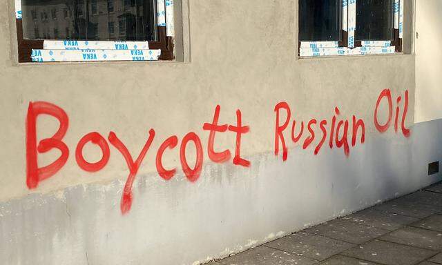 Ein rotes Graffiti, Schriftzug mit roter Schrift an einer grauen Hauswand in Bremen Neustadt mit dem Text Boycott Russi