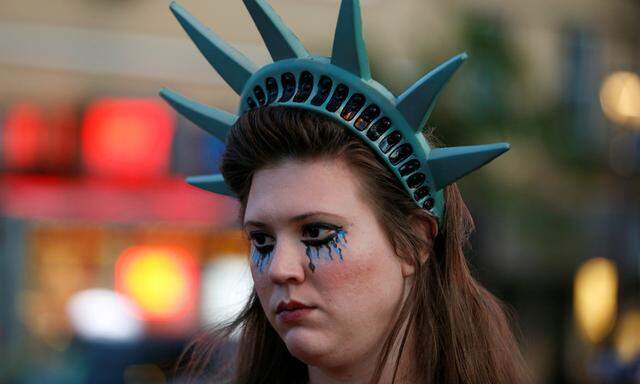 A demonstrator wears a headpiece depicting the crown of the Statue of Liberty during a protest in San Francisco, California, U.S. following the election of Donald Trump as the president of the United States