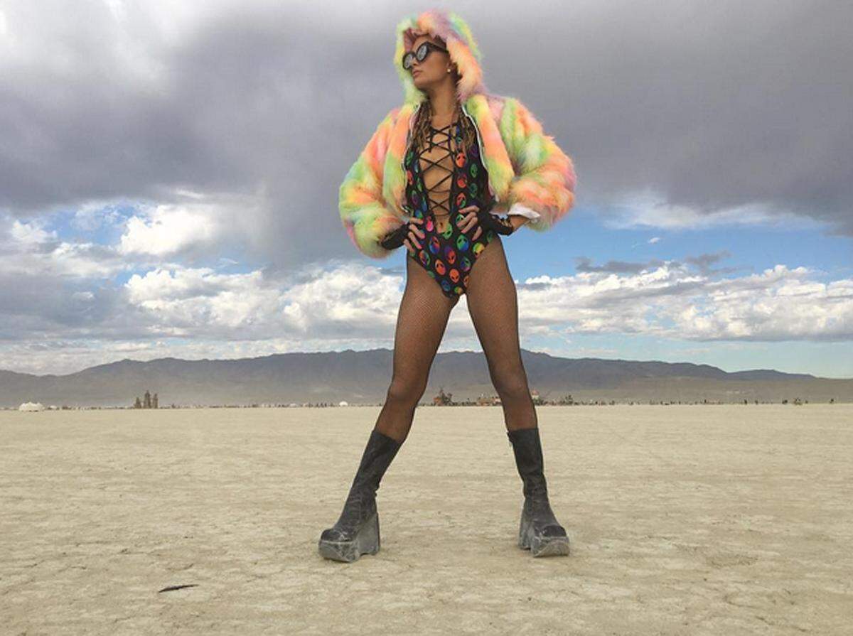 Einmal im Jahr wird die Black Rock Desert in Nevada während des Burning Man Festival zu einer Stadt auf Zeit. Mit von der Partie sind viele Stars, darunter auch Paris Hilton, die sich jeden Tag aufs Neue mit gewagten Neon-Outfits in Szene setzt.