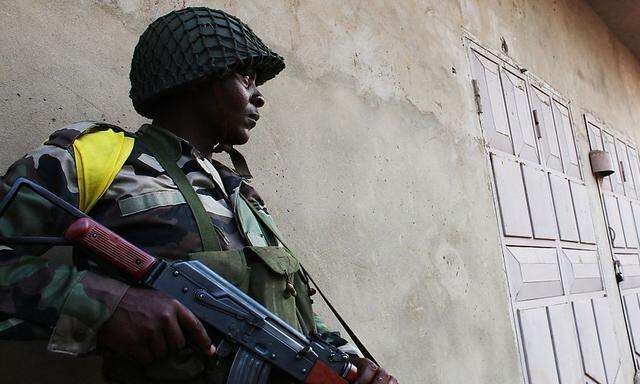 An Africa Union peacekeeping soldier takes a strategic position to quell street violence in neighbourhoods in Bangui