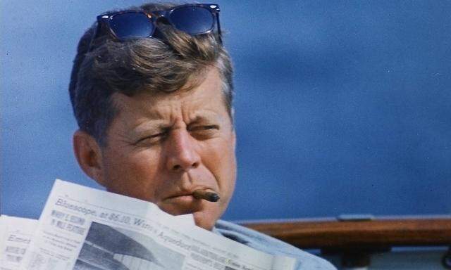 Hyannisport Weekend President John F Kennedy with cigar and New York Times Hyannisport MA aboar