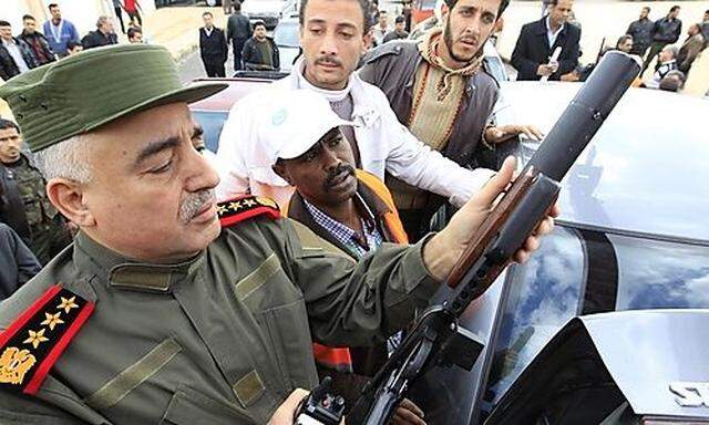 Syrian officer shows Arab league monitor weapon confiscated from what officials say were gun men, dur
