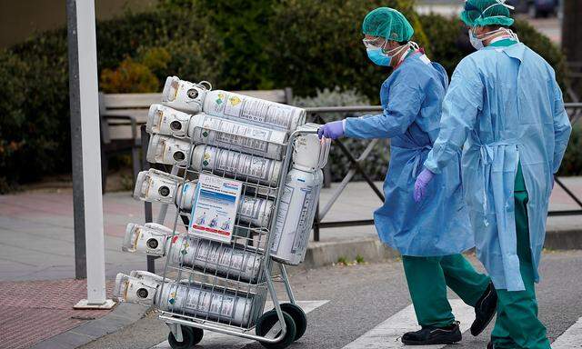 Ein Bild aus Madrid, wo Krankenhausmitarbeiter eine neue Lieferung Sauerstoffflaschen erhalten.