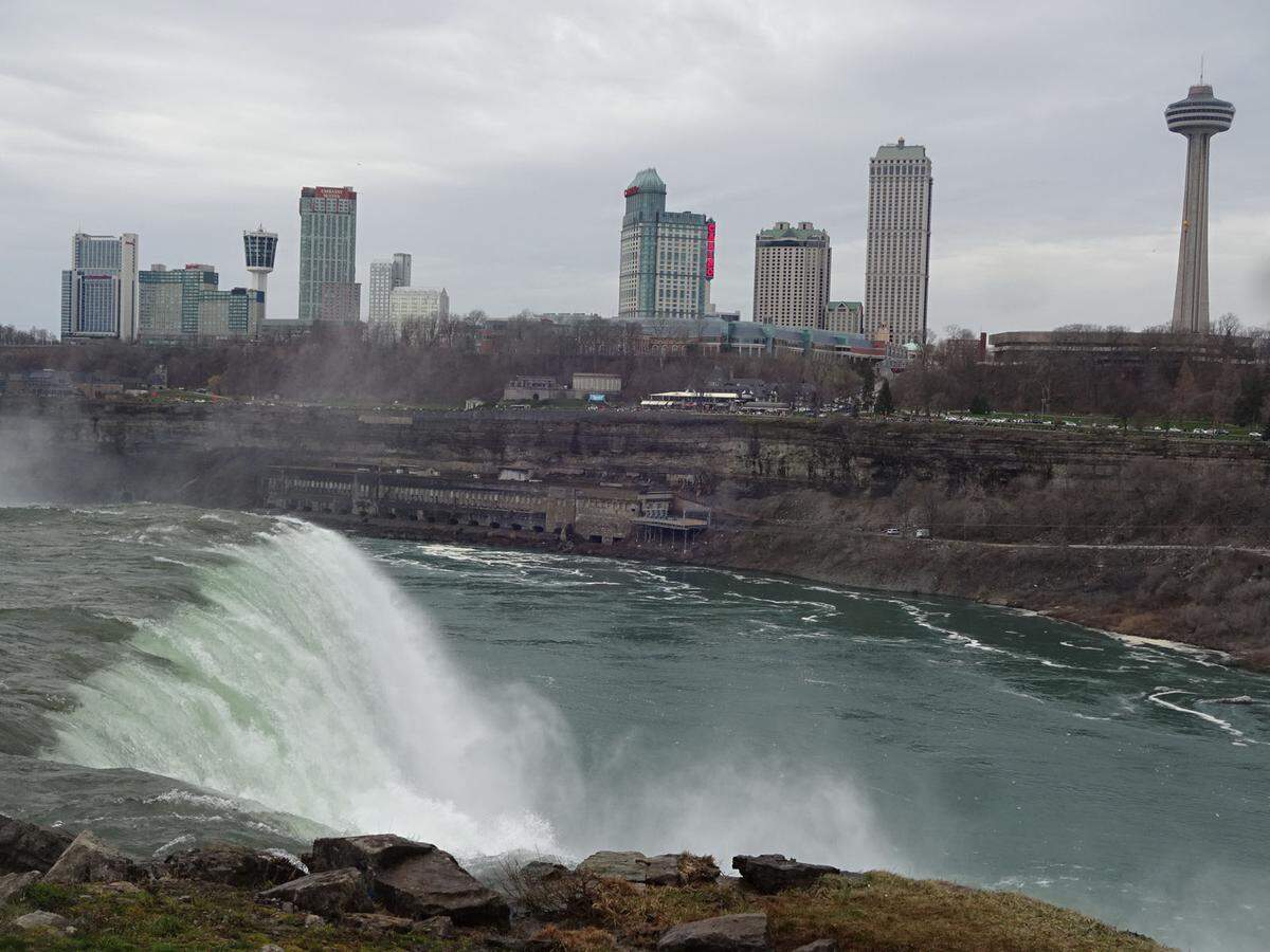 Blick über die American Falls nach Kanada, wo der größere Rummel ist. Einen Sturz über diesen der Fälle hat im Gegensatz zu jenem der Horseshoefalls – vermutlich wegen einer darunterliegenden Schutthalde – noch kein Mensch überlebt. Neues Buch! Die besten Martin-Amanshauser-Kolumnen aus dem „Schaufenster“ gibt es jetzt im Picus Verlag unter dem Titel „Typisch Welt, 111 Geschichten zum weiter Reisen“, 20,00 EUR. www.amanshauser.at