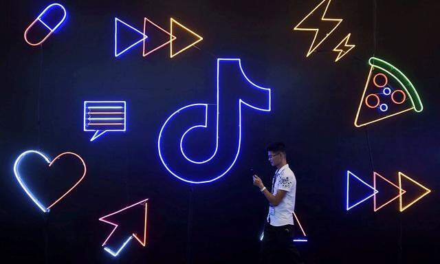 FILE PHOTO: Man walks past a sign of ByteDance's app TikTok, known locally as Douyin, at an expo in Hangzhou