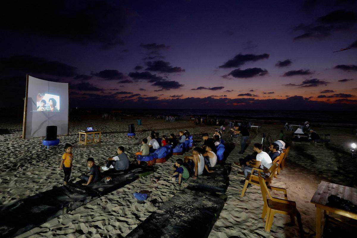 16. August. Palästinensische Familien schauen sich am Strand einen Film an, eine Seltenheit im Gaza-Streifen. 
